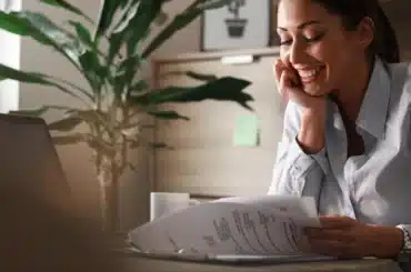 mulher recebendo certidão de ônus reais antes de comprar imóvel